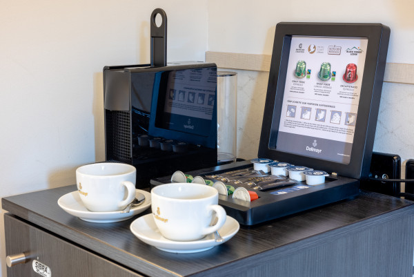 Nespresso MAschine mit Kaffeetassen Zucker, Milche, Kapseln, bereit für den Einsatz