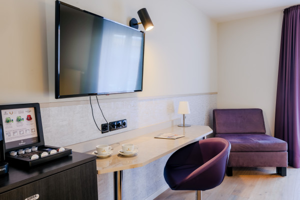 Tisch mit Stuhl, Sessel, TV und Kaffeemaschine Nespresso