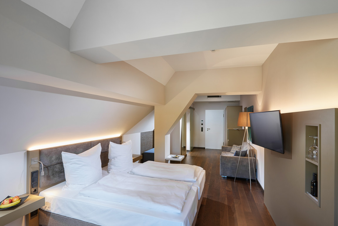 Großzügiges modernes Doppelzimmer mit TV Sofa und Dachschräge
