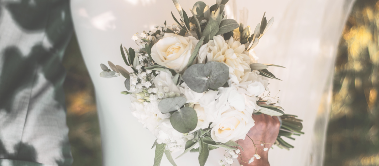 Brautstrauß mit weißen und rosa Rosen sowie grünen Blättern