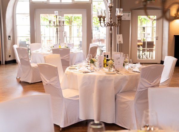 Hotel Schloss Reinach Saal Reinach Hochzeitsdekoration gedeckte Tische mit Blick zum Bogenfenster