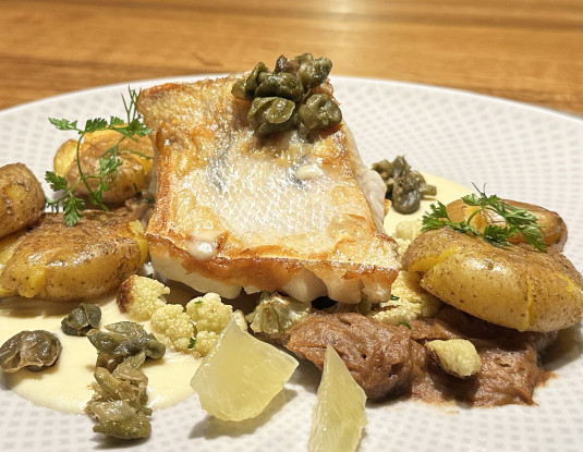 Zanderfilet mit Kartoffeln auf einem liebevoll angerichteten Tisch des Hotels 