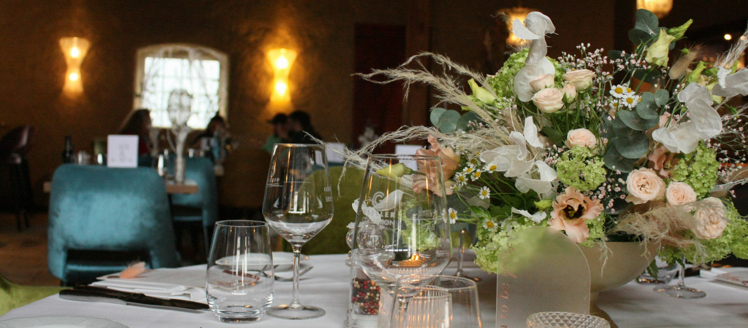 Festlich gedeckter Tisch mit großem Blumenstrauß, Weingläsern
