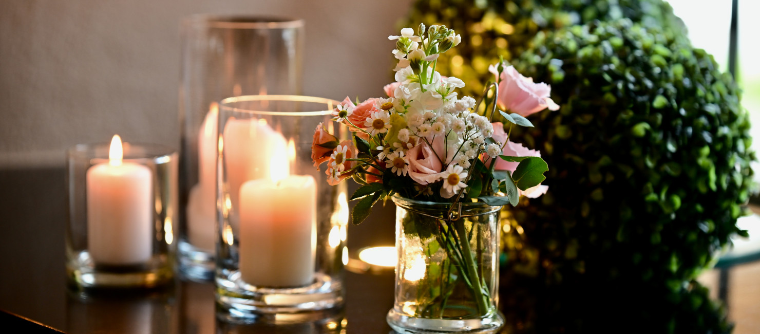 Festively decorated table with bouquet of flowers and lit candles