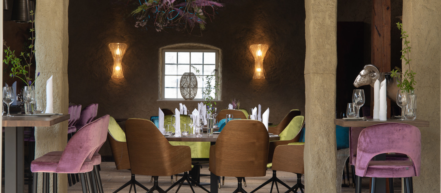 Eleganter Restaurantbereich mit bunten Sesseln, gedeckten Tischen 