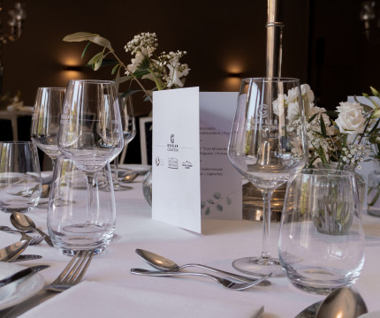 Festlich dekorierter Tisch mit weißen Blumen, Weingläsern und einer Menükarte